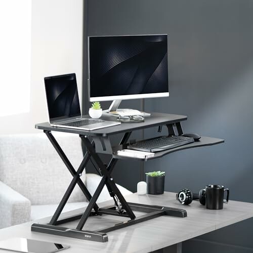 Adjustable standing desk with laptop and monitor in a modern office.