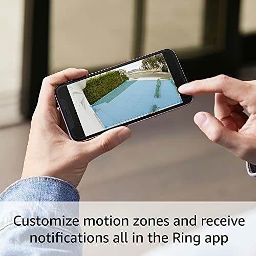 Person customizing motion zones on Ring app via smartphone.