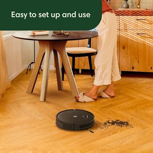 Robot vacuum cleaner on wooden floor near dining table, easy to set up and use.