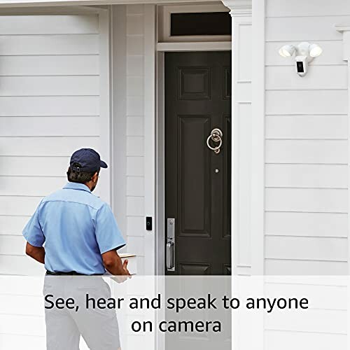 Person approaching a front door with a smart doorbell camera and motion-activated light.